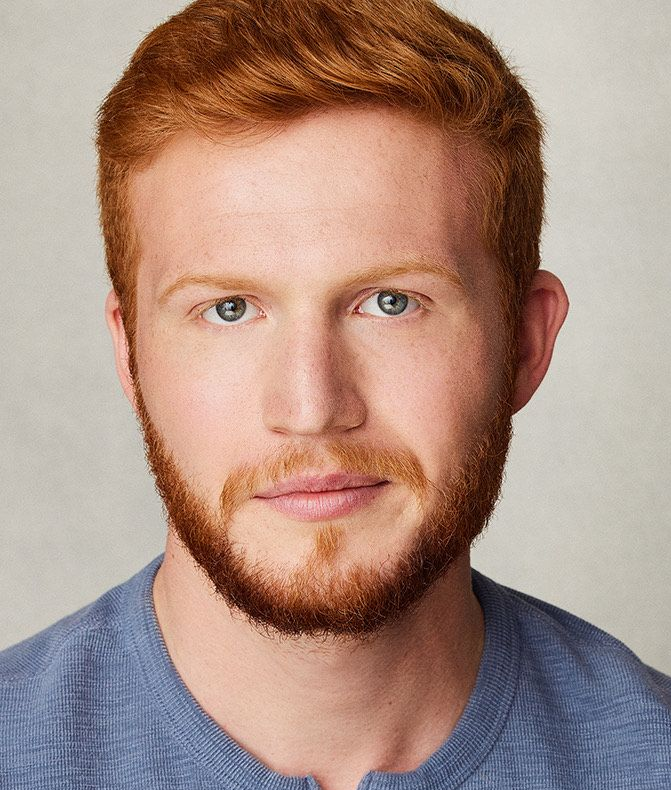 A man with red hair is posing for a photo.